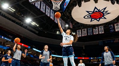 WNBA常规赛芝加哥天空队主场，球员们正在进行赛前热身投篮，场馆顶部悬挂着天空队历年荣誉旗帜